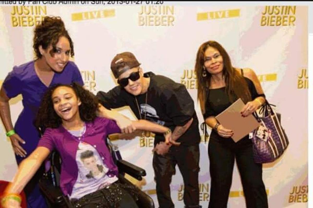 Angelyn Gutierrez, seated, is pictured at a concert with pop star Justin Bieber, one of her favorite singers.