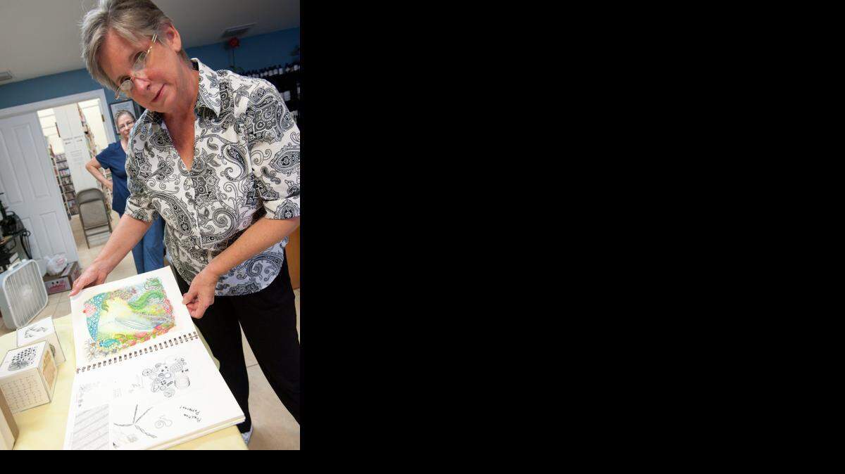 
Debbie Sagan, a crafts instructor, shows off samples of Zentangle projects she helps students make during an open house for the craft classes at Tea 'n Sanity apothecary in Kendall. 
