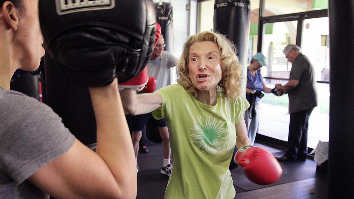 Trainer Gloria Dacosta, left, holds up boxing mitts as Barbara Galper, 78, of Chicago, takes her best shot during the Rock Steady Boxing program for Parkinson’s patients at Thump Gym in Kendall.