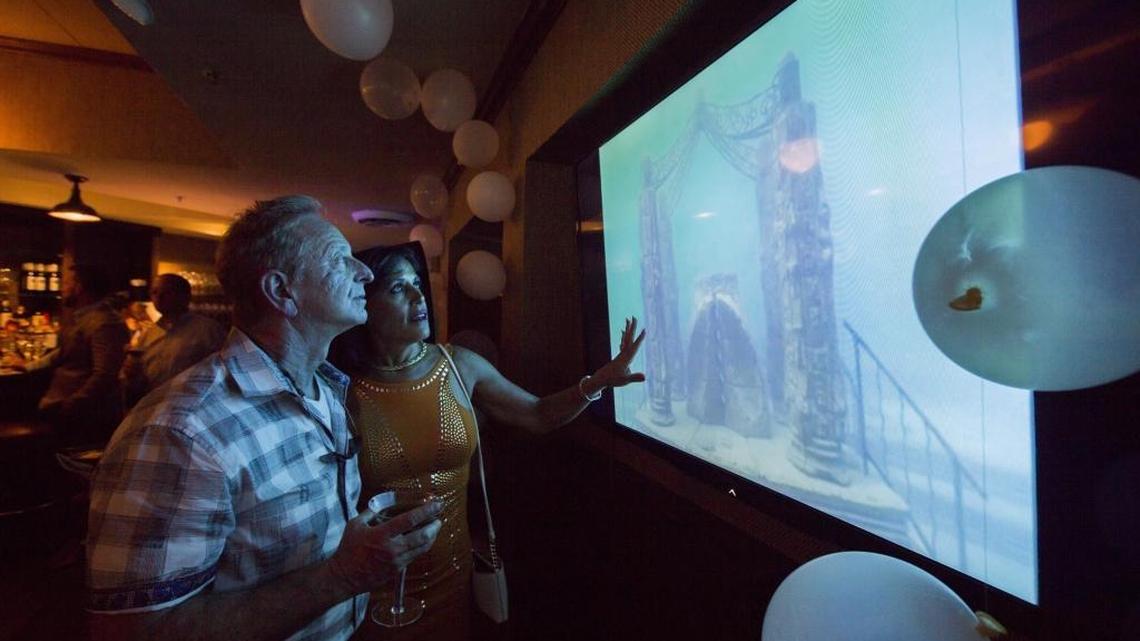 Keith Swirsky and Marianne LaChance Swirsky look at a video of the mausoleum at the Neptune Memorial Reef event to announce the enlargement of the underwater mausoleum three miles off Key Biscayne.