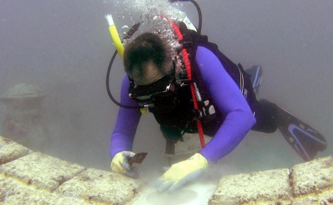 In this file photo from February 2008, artist Kim Brandell prepares a spot to place cremated remains on a section of the Neptune Memorial Reef off the coast of Key Biscayne.