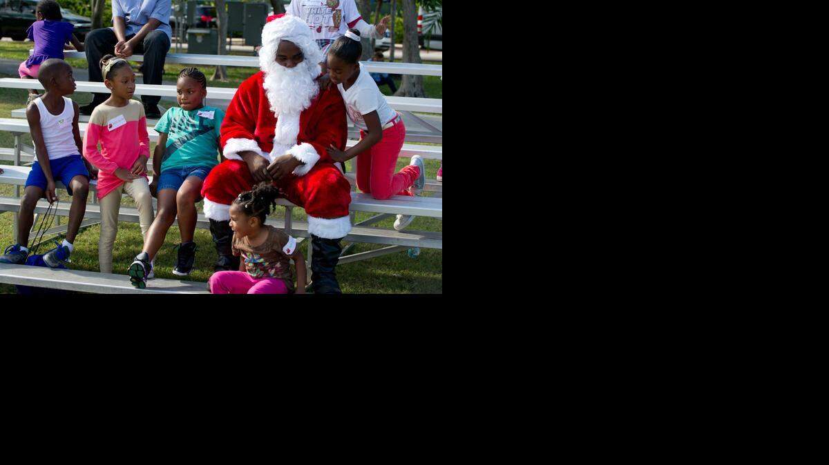 
Children hang out with Randy Dorce, dressed as Santa Claus, during a holiday party at the Village Green in Key Biscayne, Saturday, Dec. 20, 2014. The party was hosted by the Chief Press' Charitable Foundation, the Key Biscayne Community Foundation, and the Village of Key Biscayne. Scores of families that are part of the Miami Children's Initiative in Liberty City were transported to the party, where they enjoyed games, music, and lunch before receiving toys and food for the holidays.
