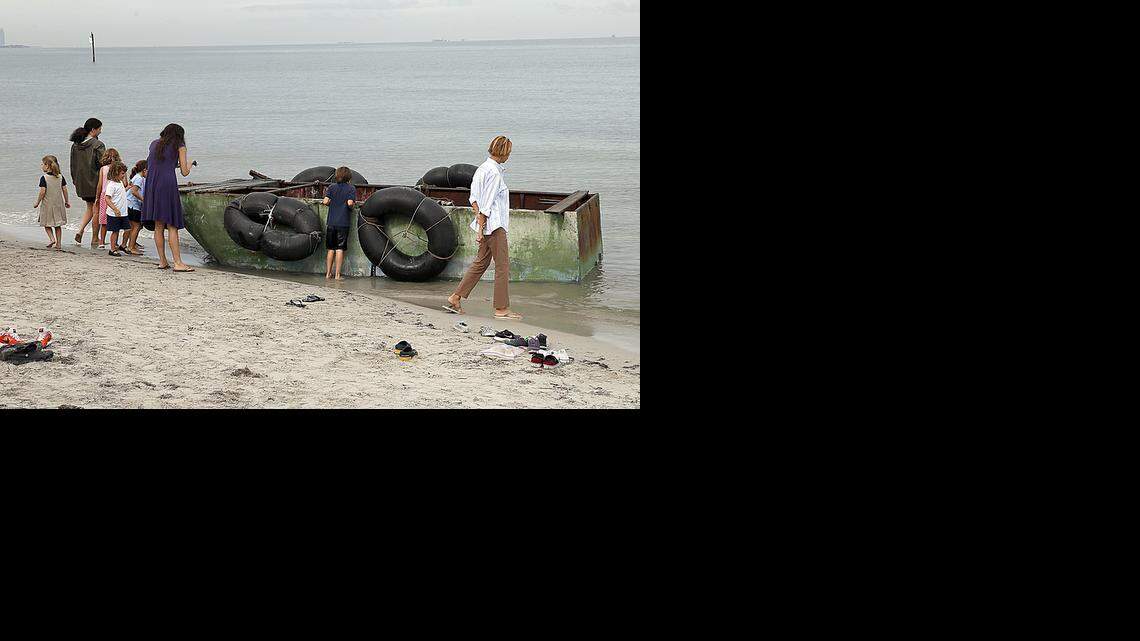 
Bystanders gather to look at a raft that landed on the beach behind the Mar Azul condominium in Key Biscayne with nine Cuban men on board on Tuesday, September 23, 2014.
