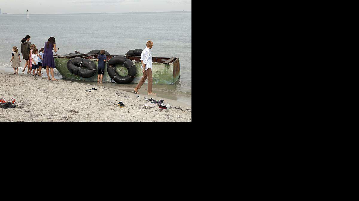 
Bystanders gather to look at a raft that landed on the beach behind the Mar Azul condominium in Key Biscayne with nine Cuban men on board on Tuesday, September 23, 2014.
