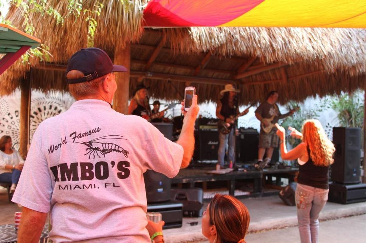 A man takes photos of people dancing to a rock 'n' roll group at the old Jimbo’s watering hole on Virginia Key.