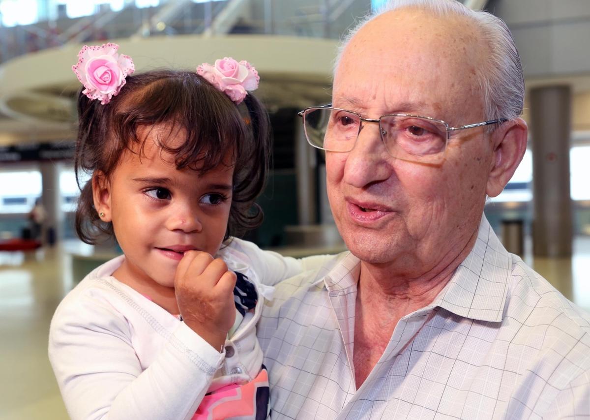 Dr. Armando Quirantes holds Alexa Vidal Prieto at the Miami International Airport on Thursday, June 21, 2018.  Quirantes will make prostheses and host Alexa and her mother for as long as the rehabilitation takes.