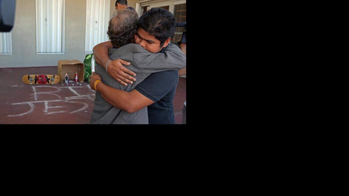 
Romelio Meneses, left, hugs his son’s best friend Jonathan Lopez Tuesday at a memorial located at Kinloch Park, where Jesus Meneses was electrocuted after jumping a fence to an adjacent FPL electrical grid.
