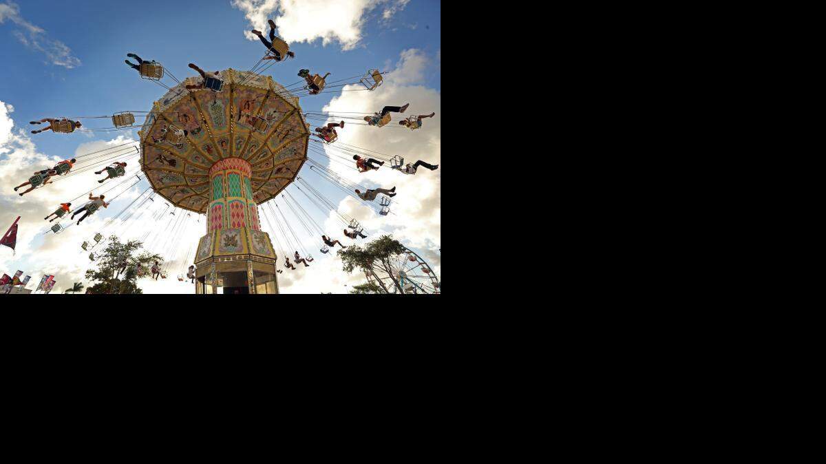 
People fly high on the swings on the opening day of the Miami-Dade County Fair & Exposition, Thursday, March 12, 2015.
