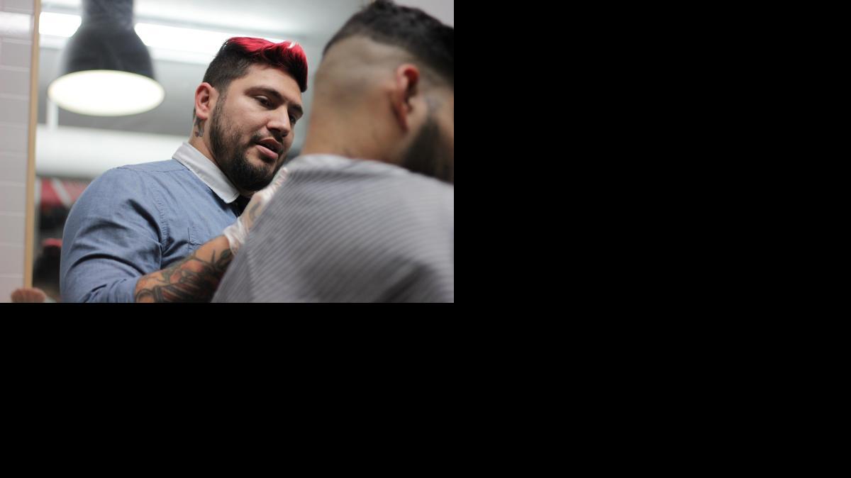 
Hamlet Garcia, 28, talks to Jonathan Perez, 25, about what he wants his haircut to look like on Dec. 13, 2014. Garcia has been cutting hair for more than five years and recently opened a new parlor shop with his girlfriend, Rachel Ringwood, 23, in Wynwood called His & Hers Parlour. Together, the couple offers clients, both male and female, haircuts.
