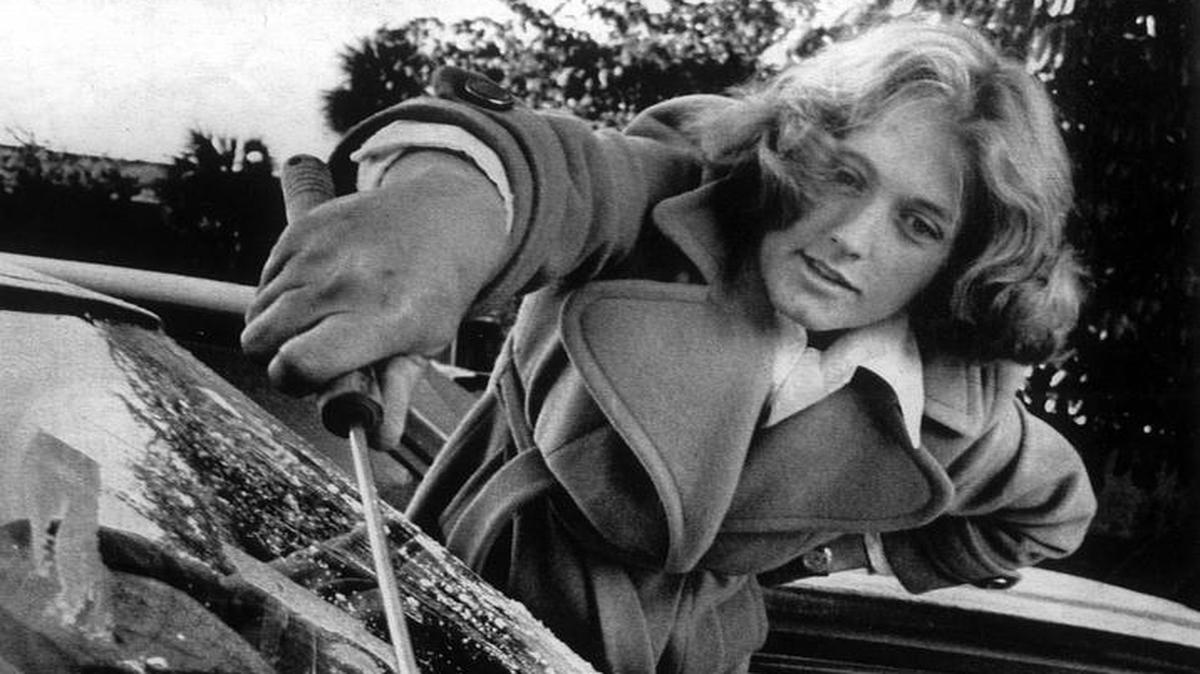 Connie Gramzow usa una espátula para raspar el hielo del parabrisas de su auto, el 19 de enero de 1977, el día que una ola de frío golpeó a Florida y produjo una leve nevada en Miami.