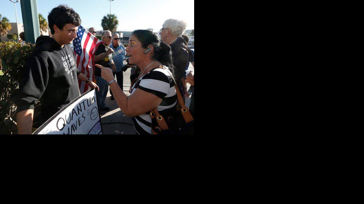 
An unidentified woman argues with Bryan Medina regarding Medina's congratulatory sign at Versailles Restaurant in Miami on Wednesday, Dec. 17, 2014 after President Obama's decision to normalize relations between Cuba and the United States
