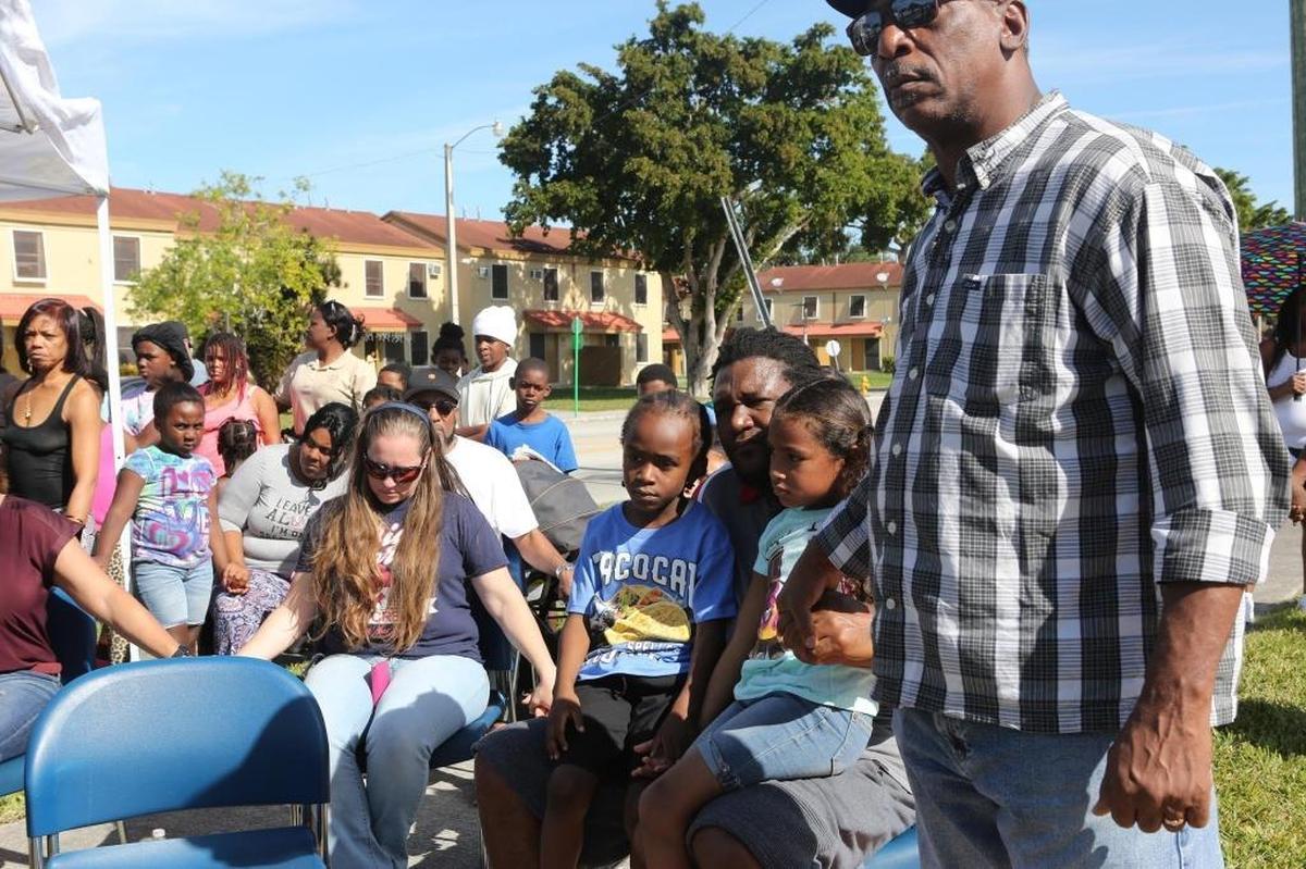 Community residents hold hands and console each other during at a gathering at Goulds Park on Saturday, Dec. 16, 2017, one day after 2-year-old Carnelle Williams-Thomas was shot and killed.