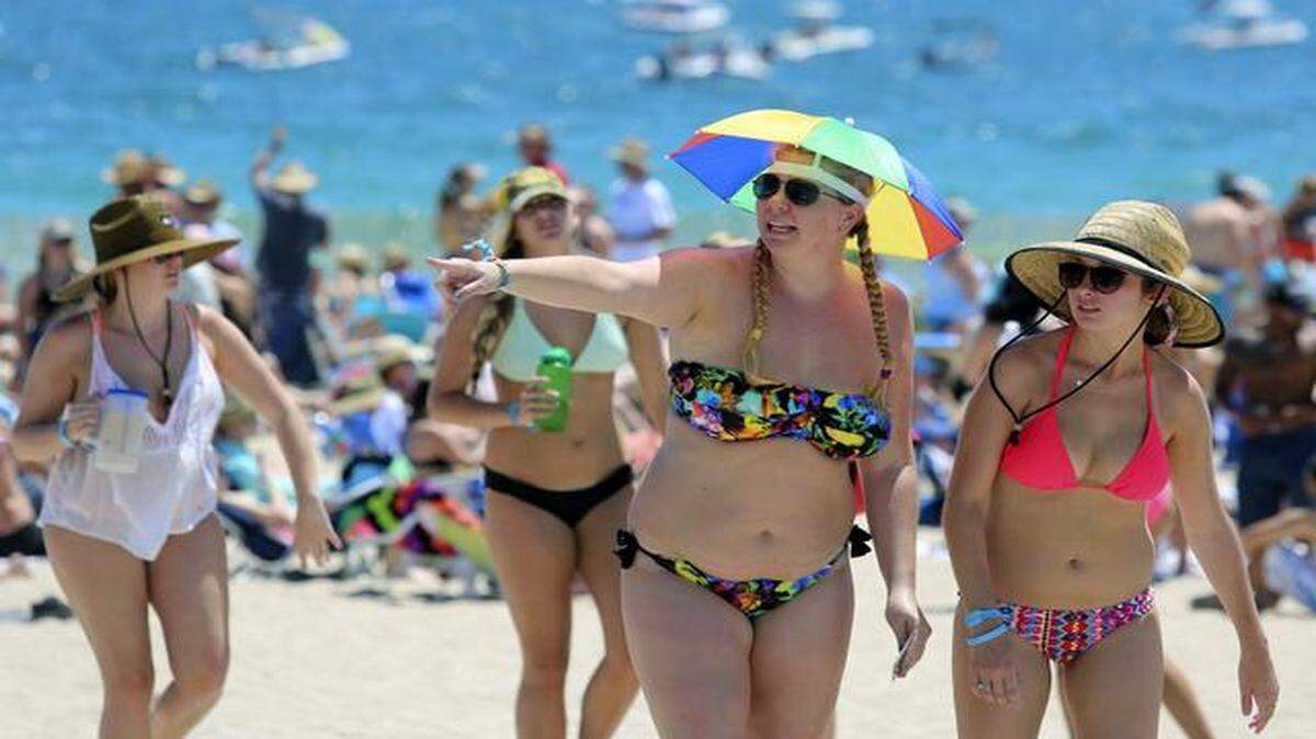 
Amber Walsh, with umbrella hat, and Megan Whitney, right, both of Cutler Bay, try and stay cool at Tortuga Music Festival at Fort Lauderdale Beach Park on Saturday, April 11, 2015. 
