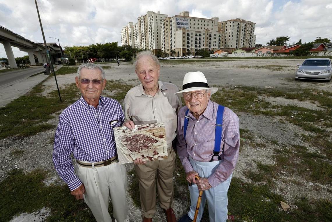 Howard Katzen, S. Ronald Pallot and Norton Pallot, partners who owned the Norton Tire Company, return to the site of their Brownsville headquarters. The vacant lot was never rebuilt after rioters burned down their facility on the southwest corner of 54th Street and Northwest 27th Avenue. The photo in hand shows the destroyed building.