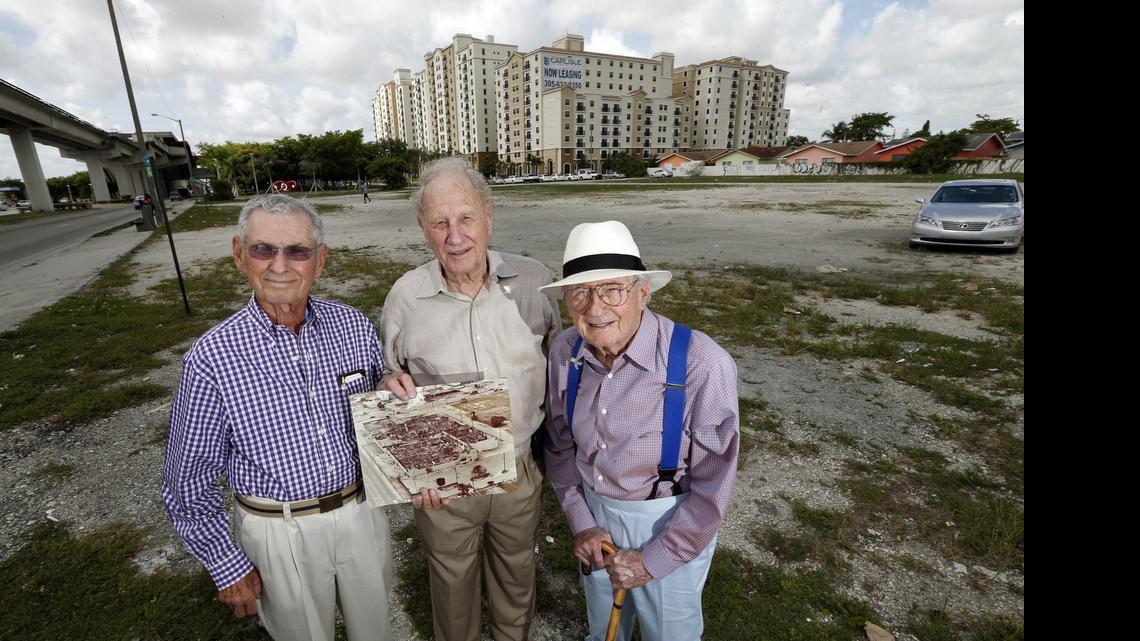 
Howard Katzen, S. Ronald Pallot and Norton Pallot, partners who owned the Norton Tire Company, return to the site of their Brownsville headquarters. The vacant lot was never rebuilt after rioters burned down their facility on the southwest corner of 54th Street and Northwest 27th Avenue. The photo in hand shows the destroyed building.
