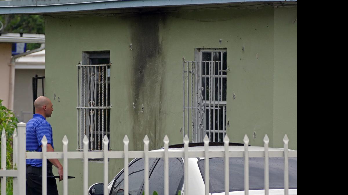 
A Miami-Dade detective looks a house that took 70 rounds of gunfire at 1171 NW 147th St. on Wednesday April 29, 2015.
