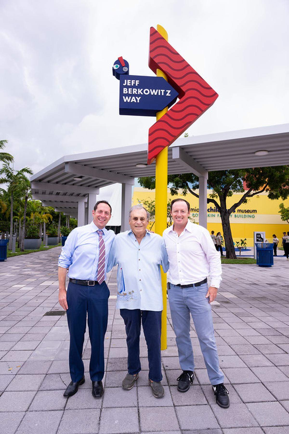 Flanked by sons Andrew (left) and Michael (right), Jeffrey Berkowitz poses before the new sign for Jeff Berkowitz Way at the Miami Children's Museum on June 13, 2024, in Miami. Berkowitz, who died on April 26, 2026, served as chair of the board for the museum.
