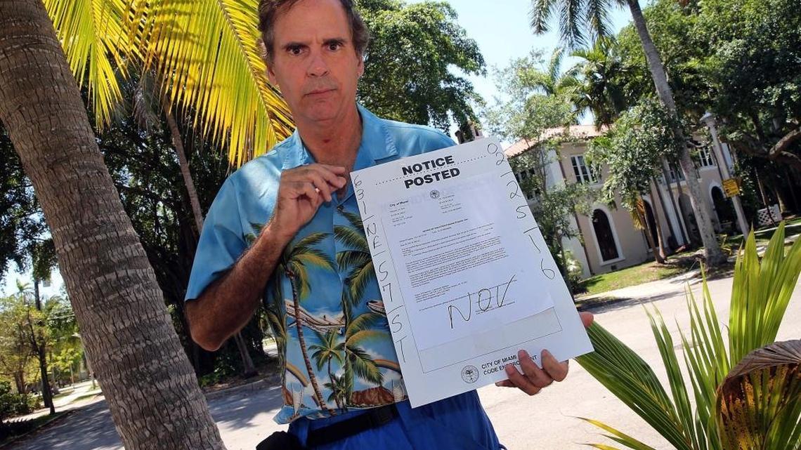 Elvis Cruz poses behind a coconut tree he planted about a year ago in Morningside. He was recently cited by the city of Miami for planting the tree in the public right and denied a tree planting permit. On Wednesday April 13, 2016.