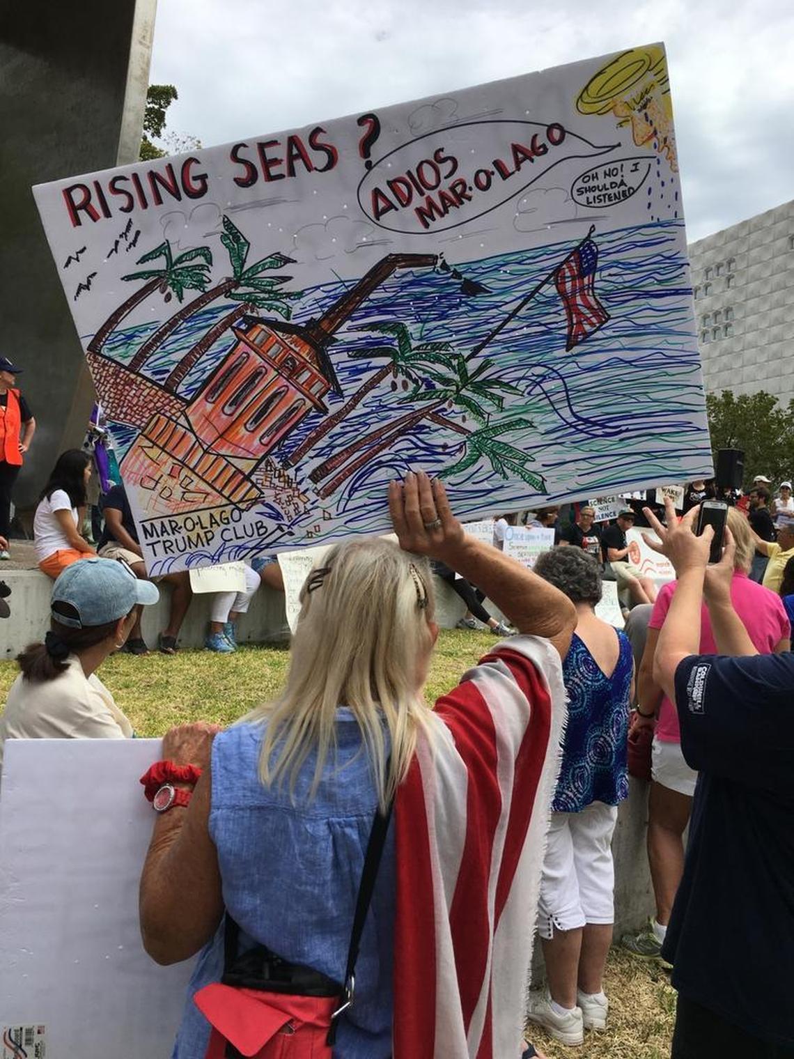 Protesters wave signs as they prepare for Miami’s March for Science on Saturday in Museum Park.