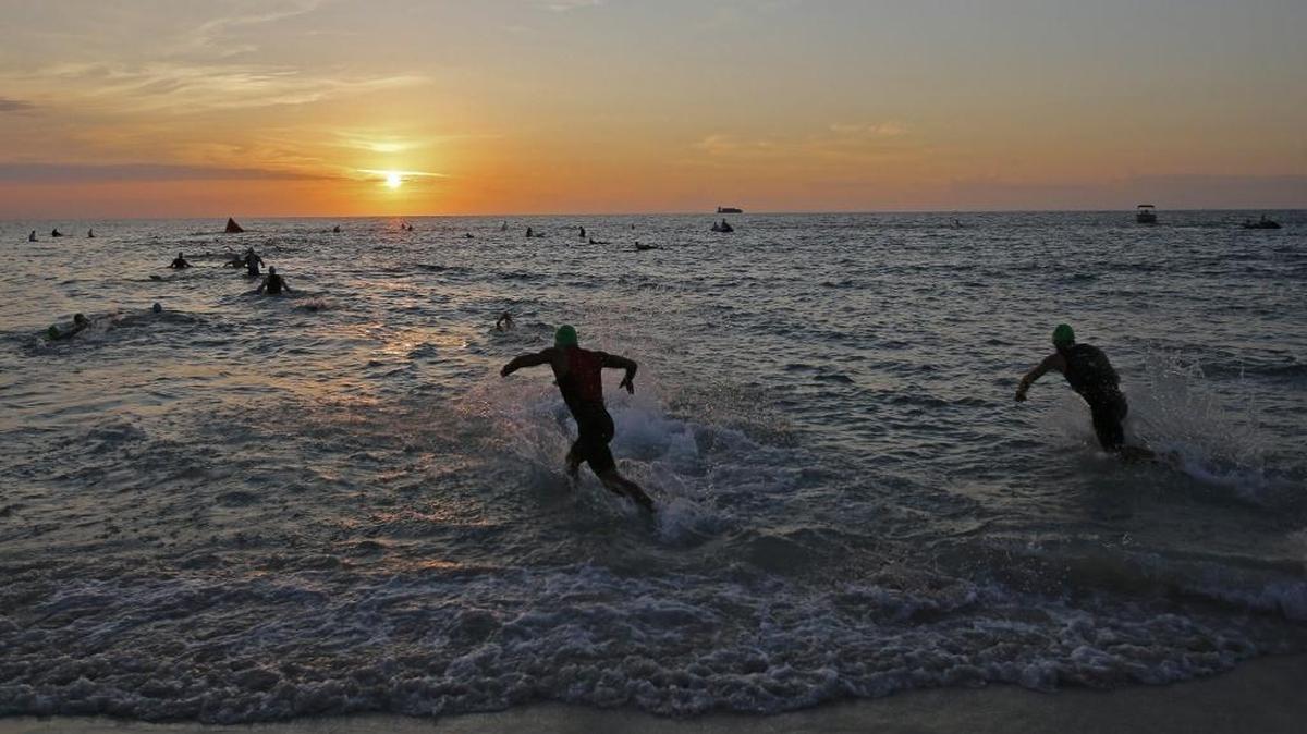 Athletes head towards the surf at the start of the swimming stage of the triathlon. About 2,000 athletes among them celebs participated in 2015 South Beach Triathlon on Sunday, April 19, 2015.