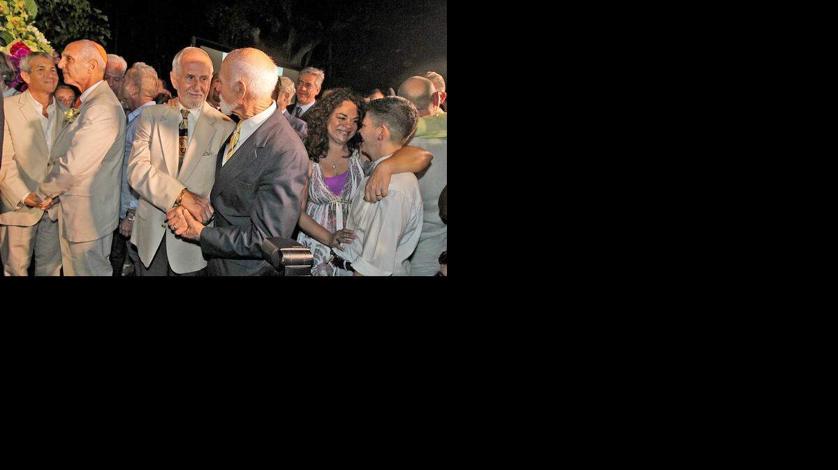 
A solemn moment: L-R Eric Hankin and Richard Milstein, Charles Hunziker and Dr. Robert Collier, and Natalie Pantaleon and Magda Noa Pantaleon renew their marriage vows at a ceremony at the Miami Beach Botanical Garden on Tuesday, January 6, 2015.
