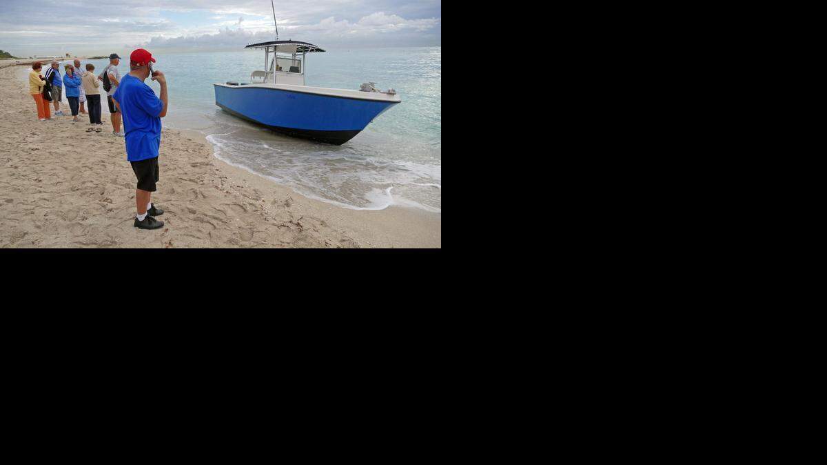 
Onlookers gather on the beach after nine migrants came ashore in the 2400 block of Collins Avenue in Miami Beach on Monday. A 24-foot boat with twin 200 HP engines rests at the location.

