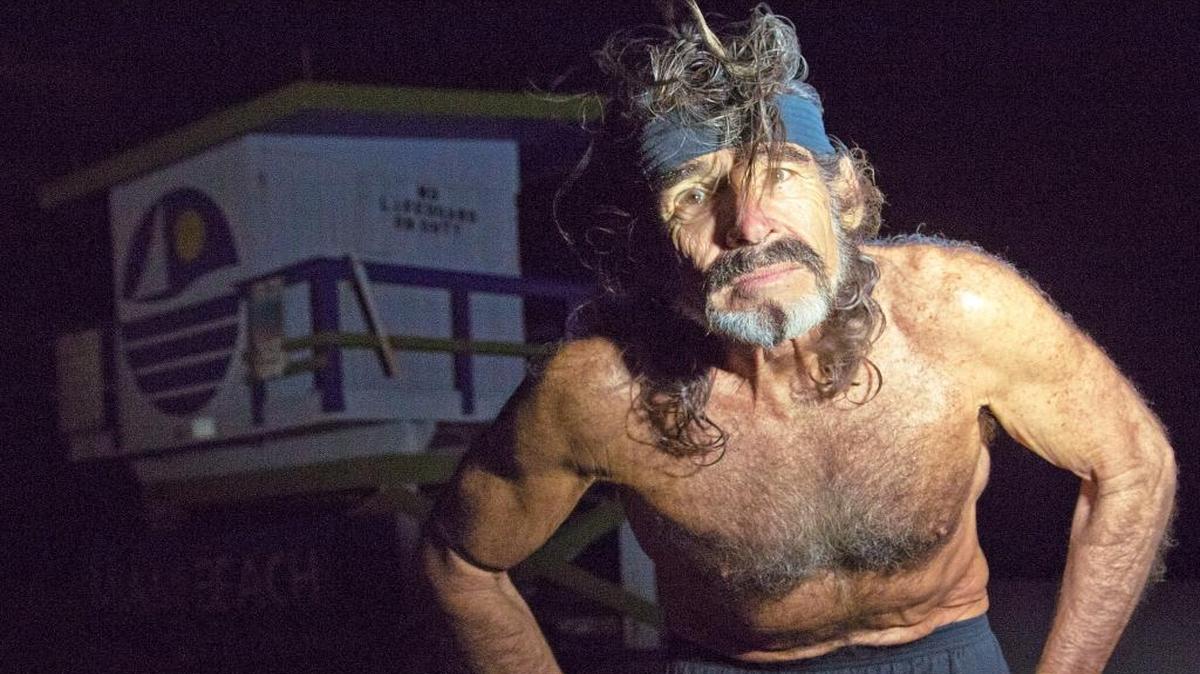 Robert “Raven” Kraft stops to be photographed after completing his 15,000th run on South Beach on Monday afternoon. Every day, he runs eight miles, starting at the Fifth Street lifeguard stand. He hasn’t missed a day since Jan. 1, 1975.