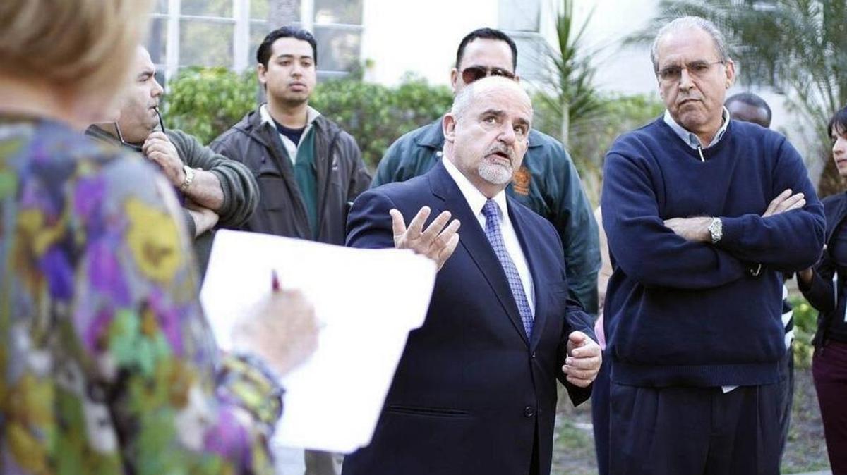 Mariano Fernandez, center, was fired from his job as building director in Miami Beach amid allegations he received free hotel stays from a hotelier who received permits from his department.