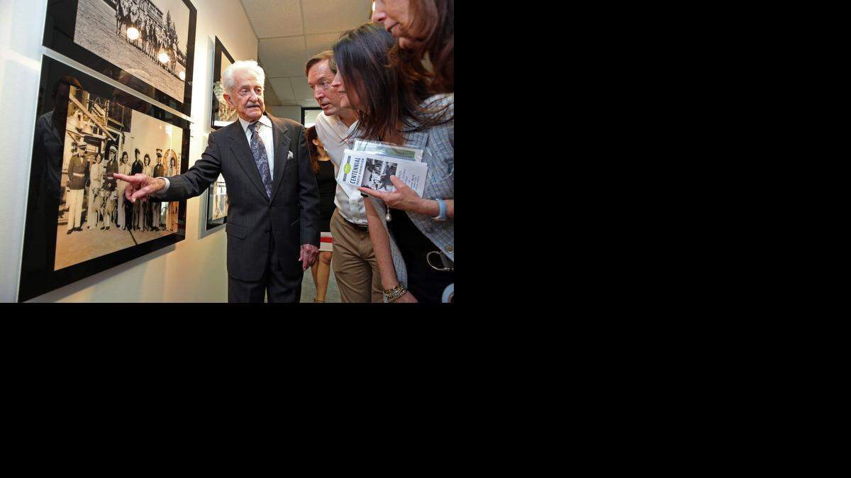 
Remembering when: Aristotle Ares, 91, a former city of Miami engineer with the public works department, points to an old friend  in a 1930’s photo from the Miami Beach Kennel Club at Miami Beach City Hall on Wednesday. Next to Ares are, from left, David Desmond, Andrea Holtz (Ares’ daughter) and Lisa Desmond.

