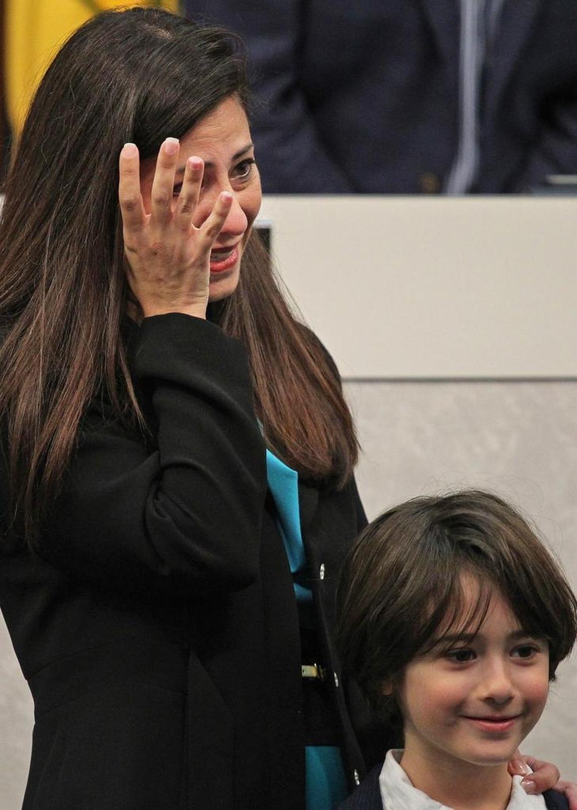 Newly sworn-in Miami Beach Commissioner Micky Steinberg, left, wipes back tears as she stands next to her son and listens to her daughter’s remarks at the City Hall ceremony on Monday, Nov. 13, 2017.