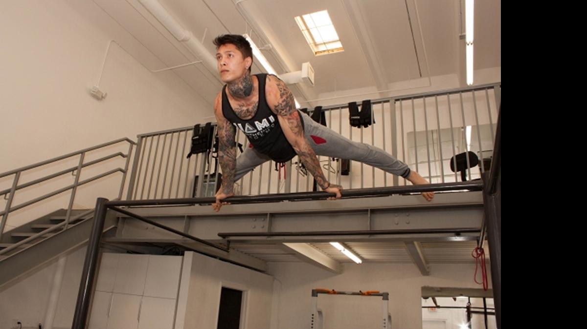 
Chris Heria, owner of Calisthenics Academy, holds a pose on the pullup bar.
