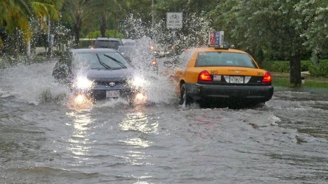 Cars go through flooding caused by heavy rains at North Bay Road and West 21st Street in Miami Beach on Aug. 1, 2017. Miami Beach is asking for an outside panel of experts to review the city’s anti-flooding program.