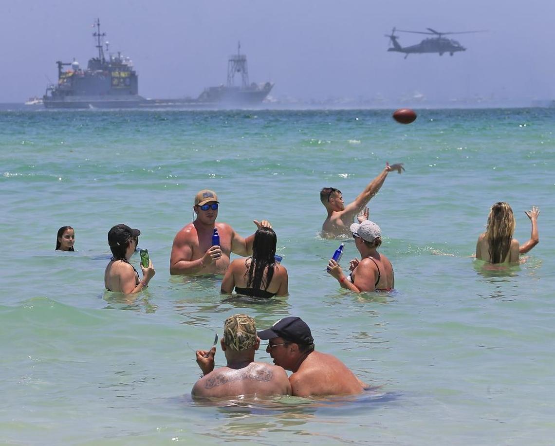 Beach goers enjoy the view as Air Force HH-60 Pave Hawk helicopters perform at the air and sea show in Miami Beach on Sunday.