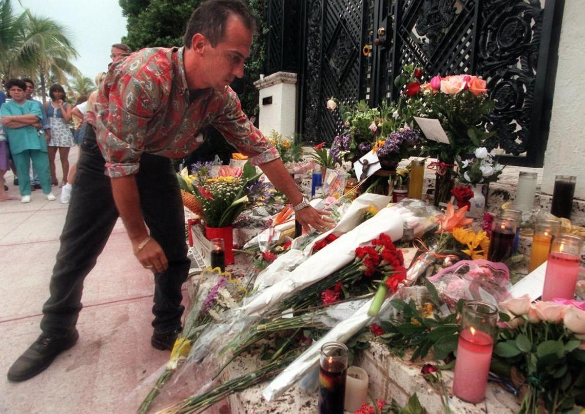 Miami Beach resident Hector Balmori lays a 90-year-old Spanish crucifix down on the bloody steps where fashion designer Gianni Versace was slain in front of his Ocean Drive mansion.