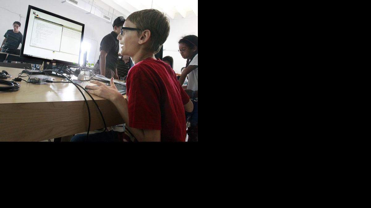 
Savion Steinmetz, 11, of Aventura, grins as he is the first to successfully launch a code during a hands-on computer workshop led by Ajit Jaokat at The LAB Miami. A U.S. Census report released Thursday shows about 78.3 percent of people in Florida reported using high-speed Internet.
