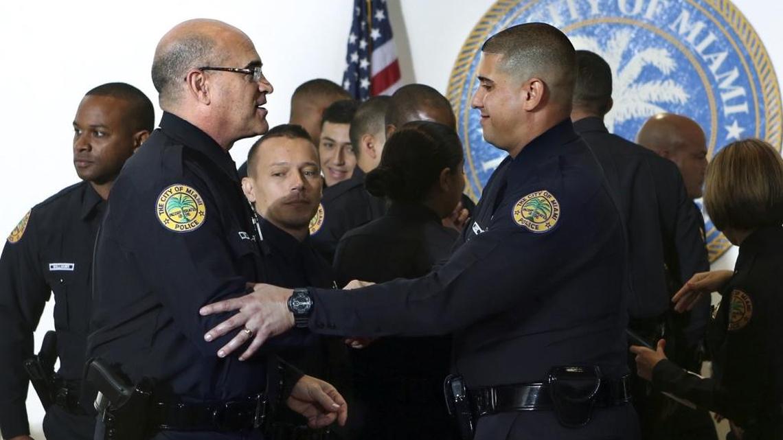 Ed Tobin, 53, left, shares congratulations with Ariel Lopez after they and other recruits were sworn in as police officers for the Miami Police Department on Friday. Tobin is a former Miami Beach city commissioner.