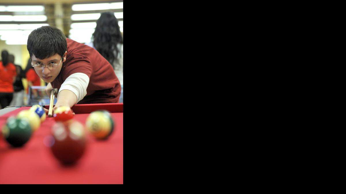 
Miami Beach Senior High freshman Walter Darocha, 14, plays pool during the grand opening of Teen Club in 2009 at the 21st Street Recreation Center.
