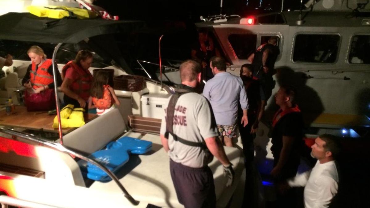 Miami-Dade Fire Rescue personnel work to rescue nine people from a boat taking on water west of Star Island.
