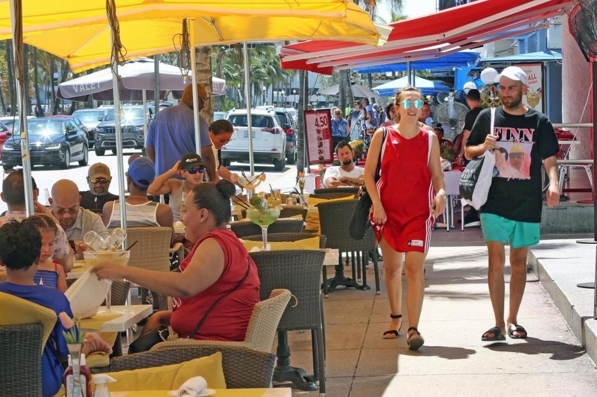 On a sunny Sunday, crowds enjoy drinks and meals on Ocean Drive. Sometimes the good feelings stop when the bill arrives.