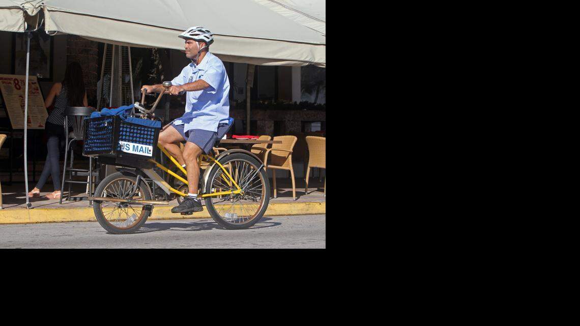 
Jesus J. Ramos, a letter carrier on Miami Beach, delivers mail on Ocean Drive Friday Dec. 19, 2014. South Beach is one of the last places in the country that still features carriers delivering mail on bicycles. 
