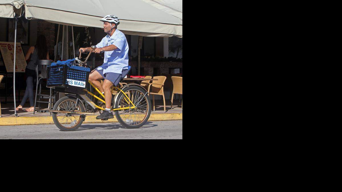 
Jesus J. Ramos, a letter carrier on Miami Beach, delivers mail on Ocean Drive Friday Dec. 19, 2014. South Beach is one of the last places in the country that still features carriers delivering mail on bicycles. 
