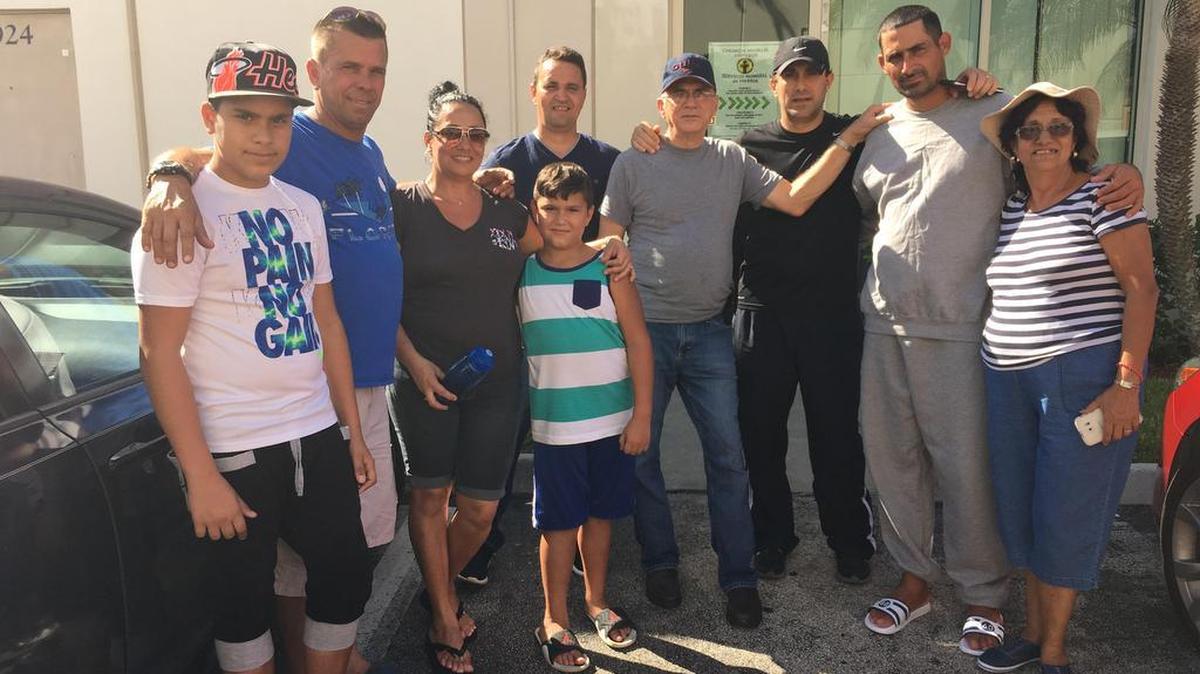 Isvanis Cabrero, second from right, is reunited with friends and family after his boat from Cuba came ashore Saturday on Miami Beach. From left are Leandro Sanchez, Francisco Sanchez, Llaisdell Cabrero, Brian Sanchez, Jose Ramon Cepedez, Orestes Cabrero , Llismell Cabrero, Cabrero and Magalis Quintanal. They gatherer at Church World Services in Doral, which is helping acclimate the five men aboard.