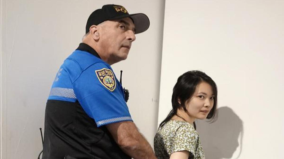 A police officer handcuffs the suspect in the stabbing of a woman at Art Basel, inside the Miami Beach Convention Center.