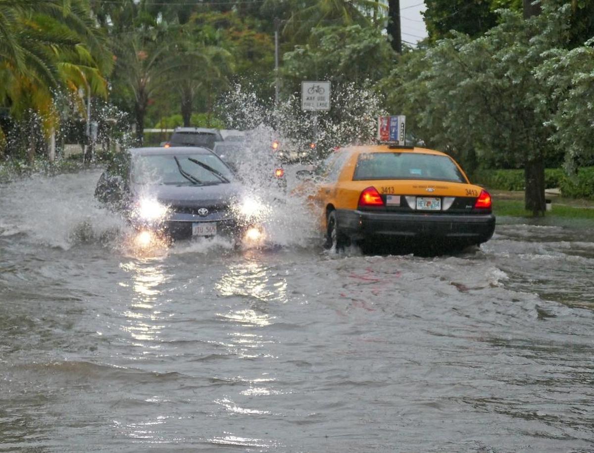 Cars goes through a flood caused by heavy rains at North Bay Road and West 21st Street in Miami Beach on Tuesday, Aug. 1, 2017.