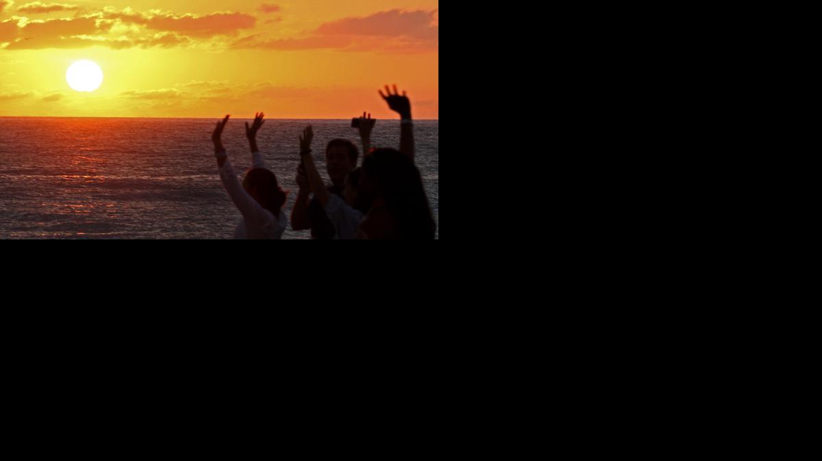 
Worshipers lift their hands to the sky as the sun rises during Calvary Miami Beach’s Easter service on Sunday.


