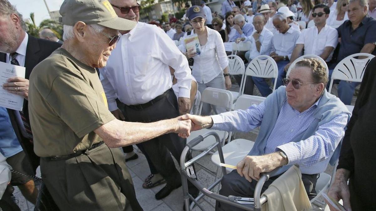 Holocaust survivor Tibor Hollo, 90, shakes hands with Harry Smith, one of the Miami Beach Holocaust Memorial founders, on Sunday, May 1, 2016.