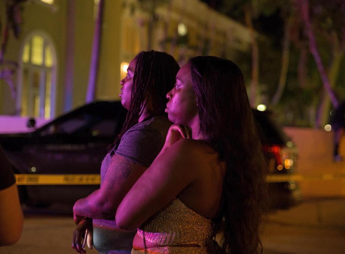 Tourists and witnesses Monique Teller, left, and Shay Davis stay at the scene where a woman was shot dead after she slammed her car into an officer on Washington Avenue at Miami Bach on Sunday, October 8, 2017.