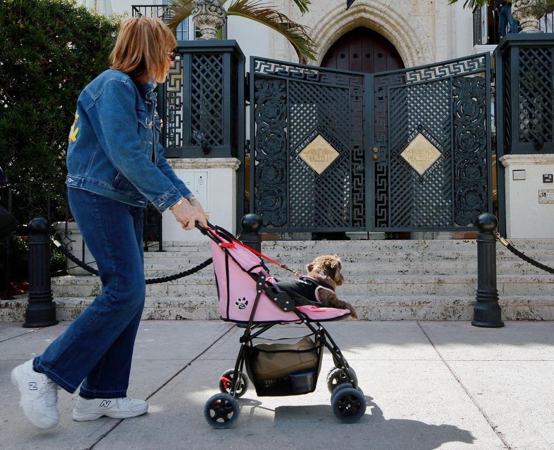 A woman pushes her poodle in a stroller, past the front gates when the Versace mansion was operating as The Villa by Barton G. in 2010.
