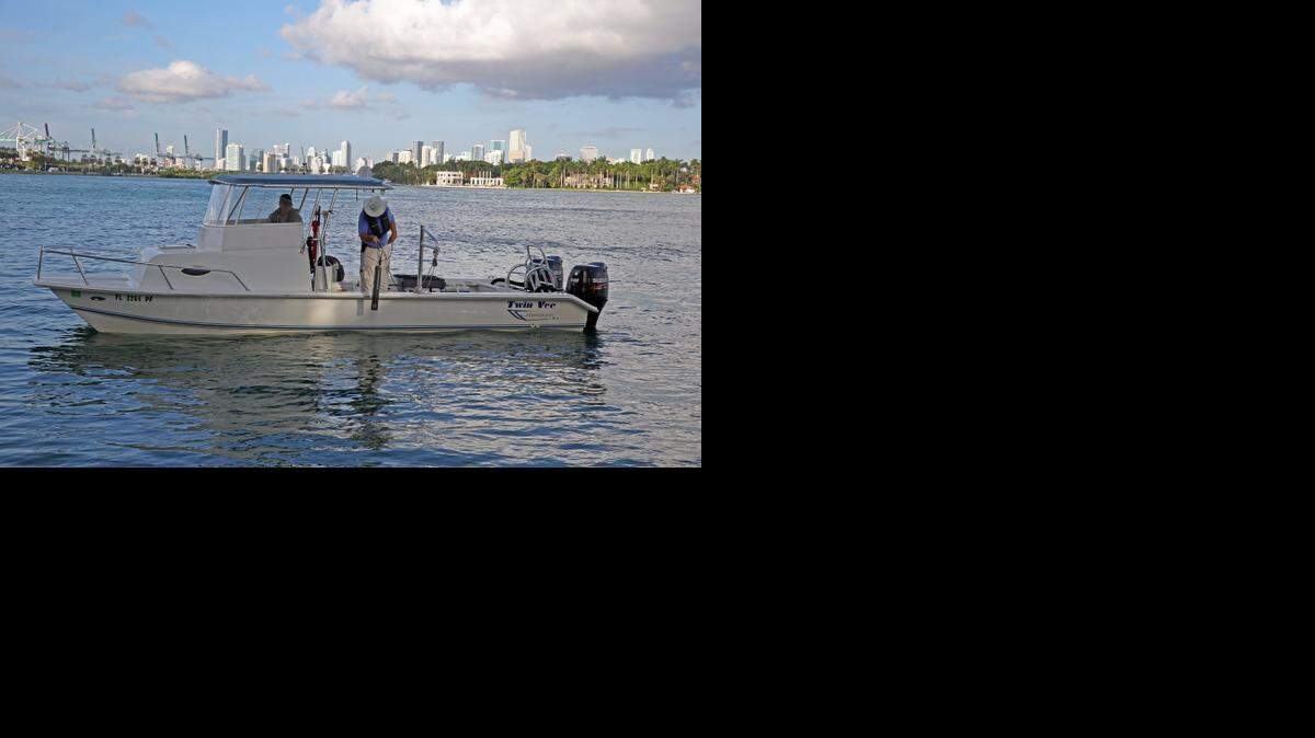 
Jeff Absten, left, research faculty at FIU, and Jim Duquesnel, marine biologist, gather water samples during the "king tide" on Miami Beach’s bay side on Thursday, Oct. 9, 2014. 

