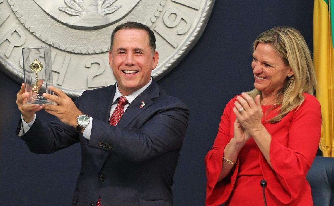 Former Miami Beach Mayor Philip Levine, left, holds up his "key to the city" given to him by Commissioner John Elizabeth Alemán during his last day as mayor inside City Hall on Monday, Nov. 13, 2017.